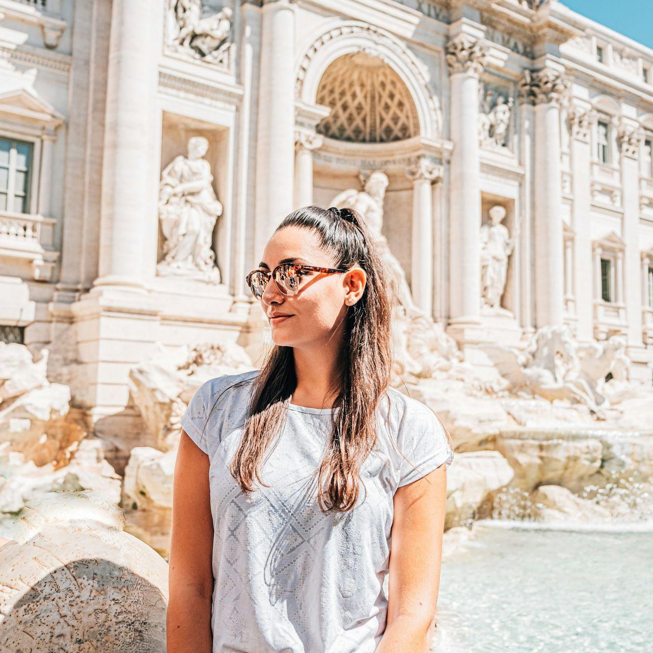 woman in white shirt wearing black sunglasses standing on water during daytime